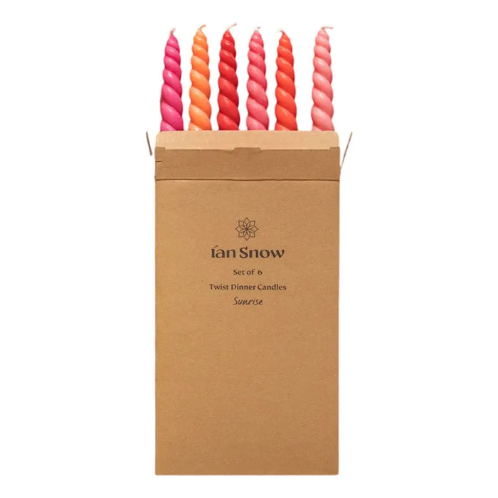 Set of six twisted dinner candles in gradient pink to orange made with coconut oil in a brown kraft box by daisy snow