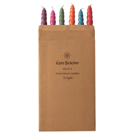 Set of six twisted dinner candles in vibrant purple pink green orange blue and red packed in brown paper by daisy snow