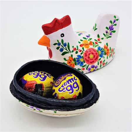 White ceramic dalit goods hen trinket box in kashmiri style with red comb holding two cadbury creme eggs