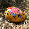 A vibrant yellow dalit goods kashmiri style solid egg with intricate pink blue and purple floral patterns outlined in black