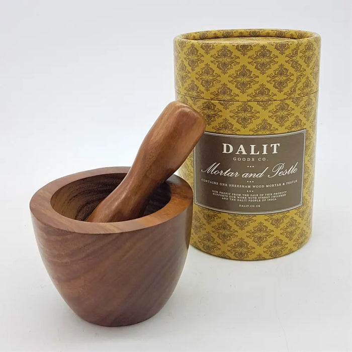 A polished dark brown sheesham wood mortar and pestle set in a decorative gold patterned box from dalit goods co