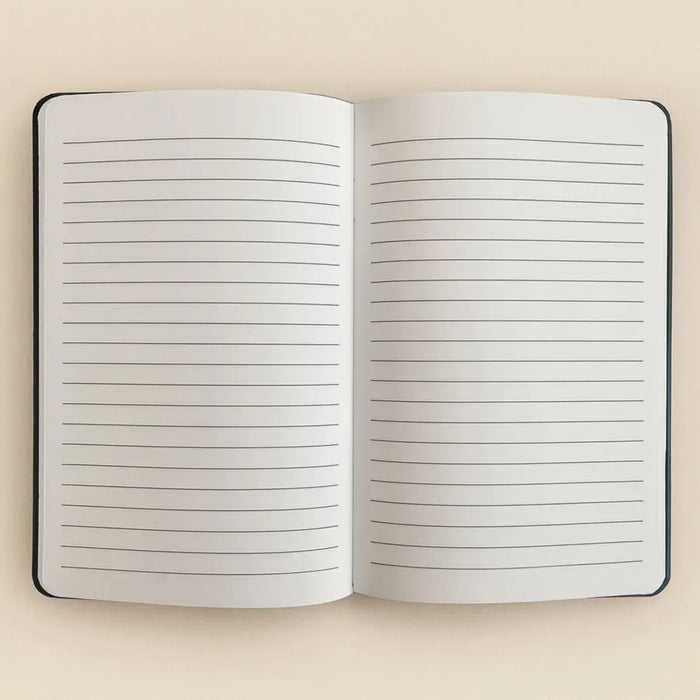 Open notebook with black binding and lined pages in a dark green velvet notebook called make it happen with 80 pages