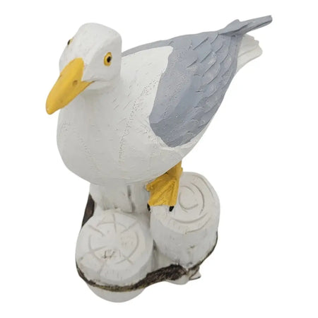 White and gray coastal seagull figurine with yellow beak and feet on a carved wooden base decorative ornament