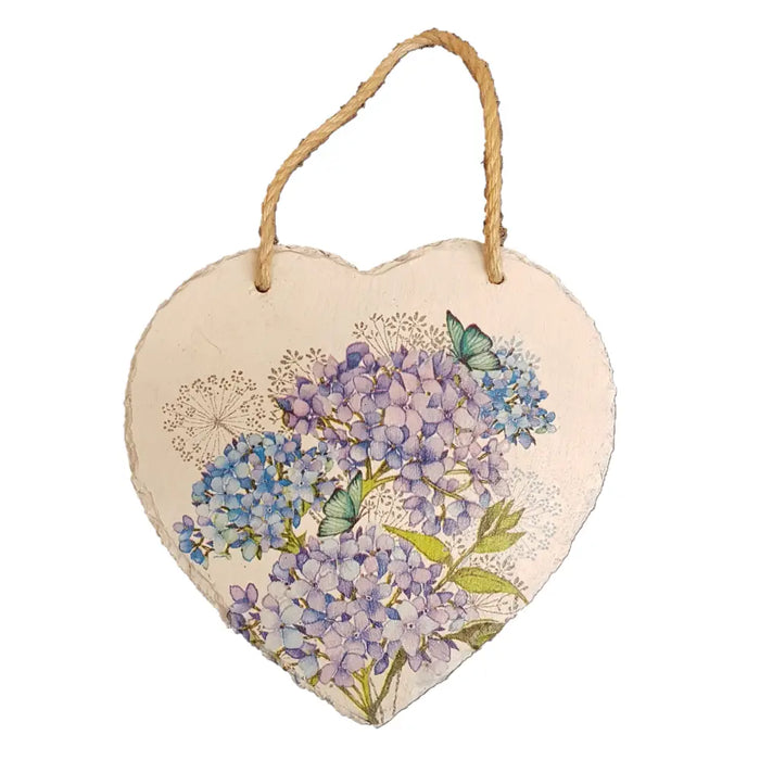 A heart-shaped slate plaque with purple and blue hydrangea print and green butterflies hanging by twine loop