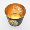 Black and gold metal votive candle holder with intricate leaf die-cut patterns for decorative use