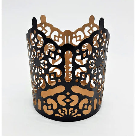 Black metal votive candle holder with die-cut patterns and warm gold interior prussian style metal votive