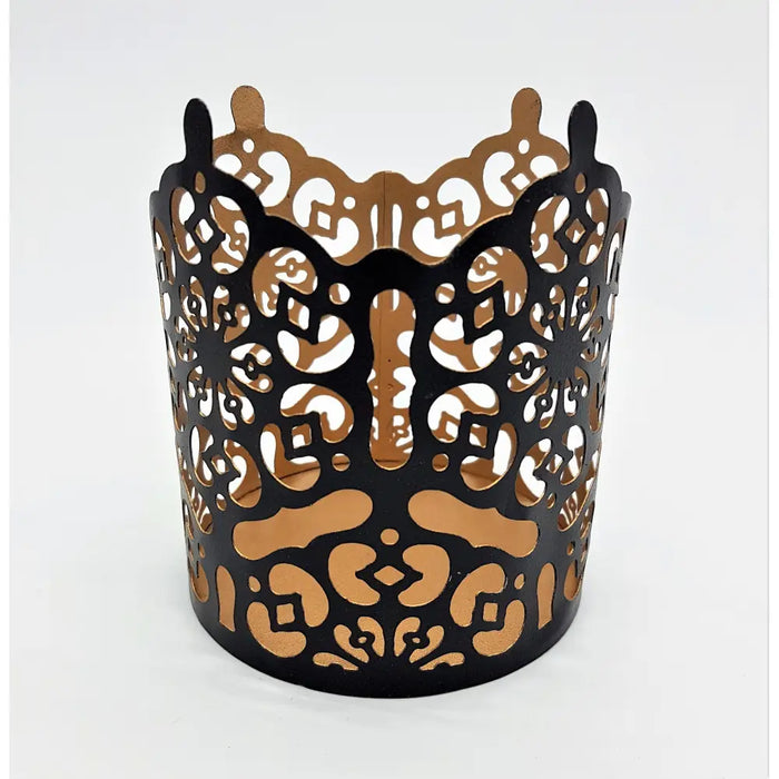 Black metal votive candle holder with die-cut patterns and warm gold interior prussian style metal votive