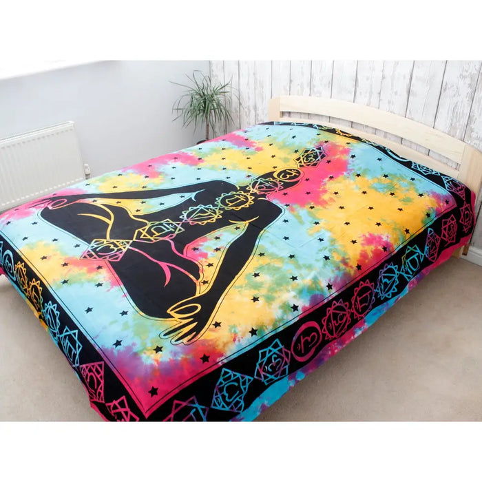 Vibrant tie-dye double cotton bedspread with a black meditating figure and colorful chakra symbols and stars