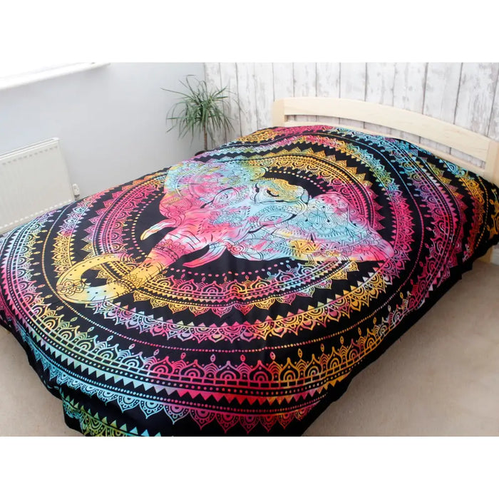 Vibrant rainbow-colored elephant head cotton bedspread wall hanging draped over a bed in a bedroom setting