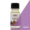 A clear glass bottle with black cap holds pale yellow dream fragrance oil featuring white floral allergen declarations