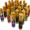 A collection of clear glass dream spirit perfume oil rollerball bottles with gold caps and colorful scent labels