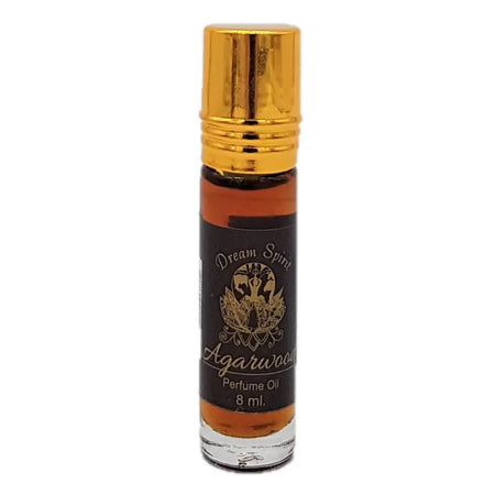 A sleek 8ml glass rollerball bottle of dream spirit amber agarwood perfume oil with a gold cap and black label
