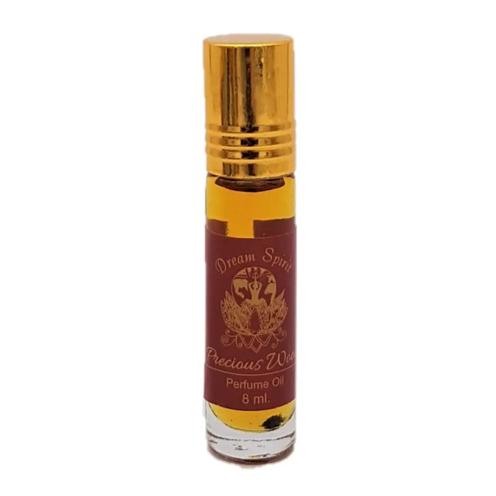 A sleek glass roll-on bottle with a gold cap containing amber dream spirit perfume oil labeled precious wood