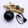 Black spherical lamp base with matte finish and integrated power cord on driftglow lamp with emerald crackle shade