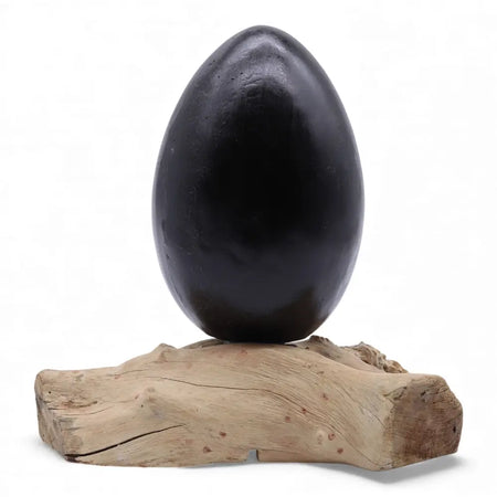 A driftglow lamp with a smooth grey crackle lava egg shade resting on a natural wood base