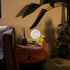A driftglow lamp with a grey luna shade featuring intricate wave patterns and soft white light glow