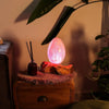 A glowing pink driftglow lamp with a translucent orange crackle fire egg shade and subtle internal patterns