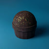 Dark brown bath bomb with textured speckled surface and gold flecks named dubai bath bomb emerald oudh truffle