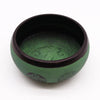 Green earth powder singing bowl with dark rim and intricate mandala buddha engravings on metal surface
