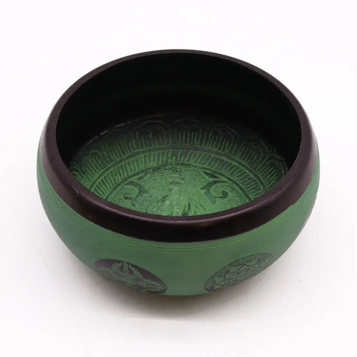 Green earth powder singing bowl with dark rim and intricate mandala buddha engravings on metal surface