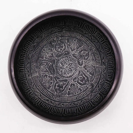 Black ceramic earth powder singing bowl with intricate raised patterns featuring five buddha symmetrical design inside