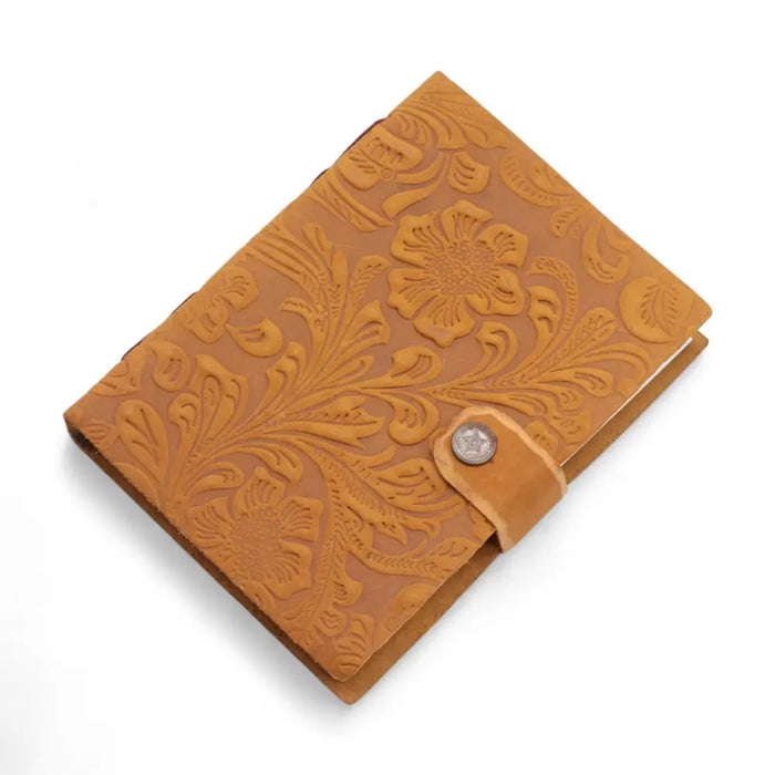 Tan leather notebook with intricate floral embossed leather design and silver button closure measuring 7 by 5 inches