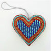 A beaded heart-shaped hanging ornament in turquoise red and blue with a silver cord from five designs collection