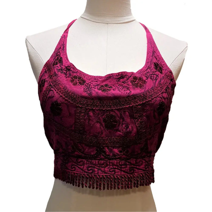 A deep magenta velvet halter neck cropped top with black floral embroidery and fringe along the bottom hem