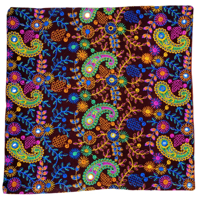 Vibrant embroidered velveteen cushion cover with neon paisley and floral patterns on deep maroon velvet background