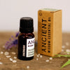A dark amber glass bottle with black cap and white label for energising essential oil blend peppermint lemon frankincense