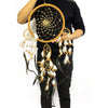 A wooden framed extra large bali dream catcher with light woven threads brown and cream feathers and wooden beads for bad dreams