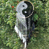 A black and white crocheted yin yang dream catcher with wooden hoop and matching feathers to catch bad dreams