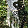 A black and white crocheted extra large bali dream catcher with yin yang design wooden beads and hanging feathers helps bad dreams