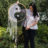 A handcrafted extra large bali dream catcher with a wooden frame and white black crocheted yin yang design to catch bad dreams