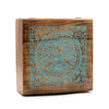 A square extra large mango wood box with a teal engraved meditating figure and tree design in a circular frame