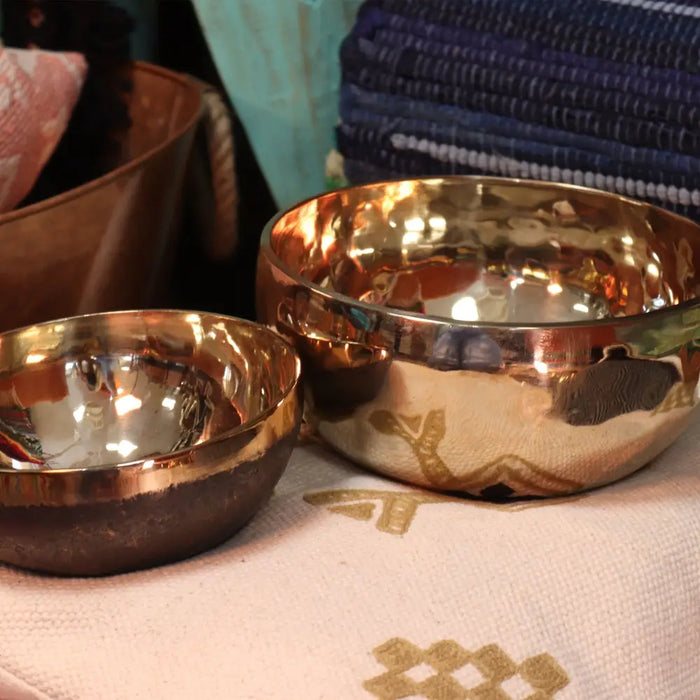 Two hand-hammered copper singing bowls one extra large with gold leaf and one smaller with reflective interiors