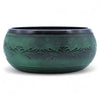 A handcrafted moss green bronze mushroom singing bowl with intricate floral etchings and a polished rim