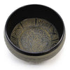 Black extra loud singing bowl with gold embossed meditative buddha and floral geometric designs on metal surface
