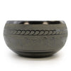 A dark gray extra loud tibetan singing bowl with engraved sanskrit script and decorative patterns made of metal