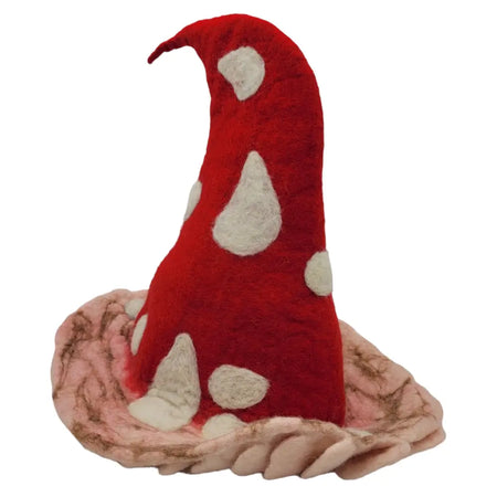 A red felt toadstool festival hat with white spots resting on a pink and brown textured base