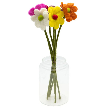 A clear glass jar holding felt daisies in pink white yellow and orange with green centers in assorted colours