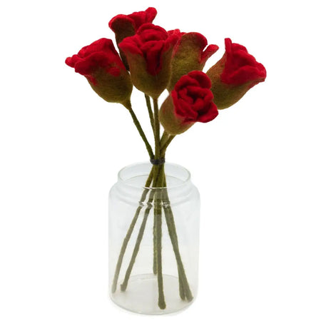 A bouquet of hand-felted red roses with green stems in a clear glass jar for decoration