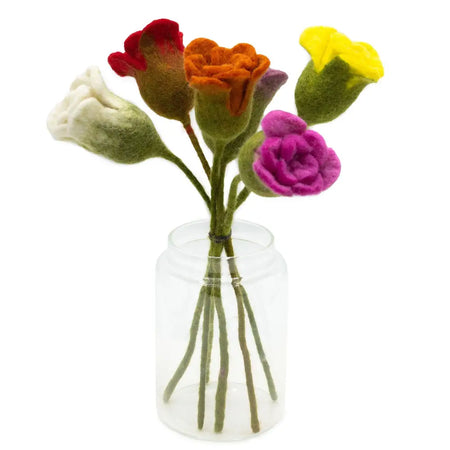 A felt flower bouquet with assorted colours of red orange yellow white and purple blooms in a clear glass jar