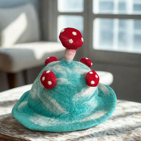 A whimsical turquoise felted mushroom hat with red polka dotted mushrooms called lost in a sky blue
