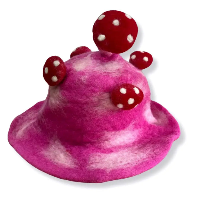 A felted mushroom hat in shocking pink with red polka dotted mushroom embellishments made of felt