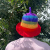 A felted sauna bowl hat in rainbow stripes with a purple tufted top made from soft felt material