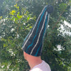 A black felted sauna wizard hat with bold teal and white stripes topped with a black pom-pom