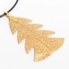 Gold festive fir leaf necklace with intricate vein detailing on a real leaves jewelry pendant and black cord
