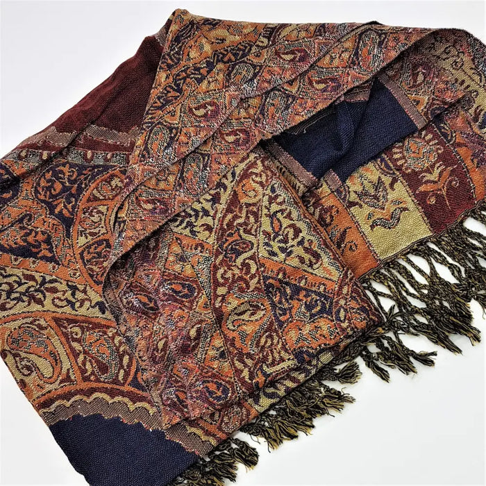 A multi-colored pashmina shawl with intricate paisley and floral patterns in rust navy beige and brown with green fringe