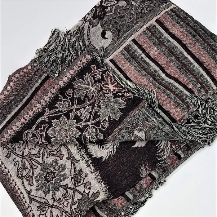 A fine woven pashmina shawl in muted black gray pink and white featuring textured floral and striped patchwork patterns